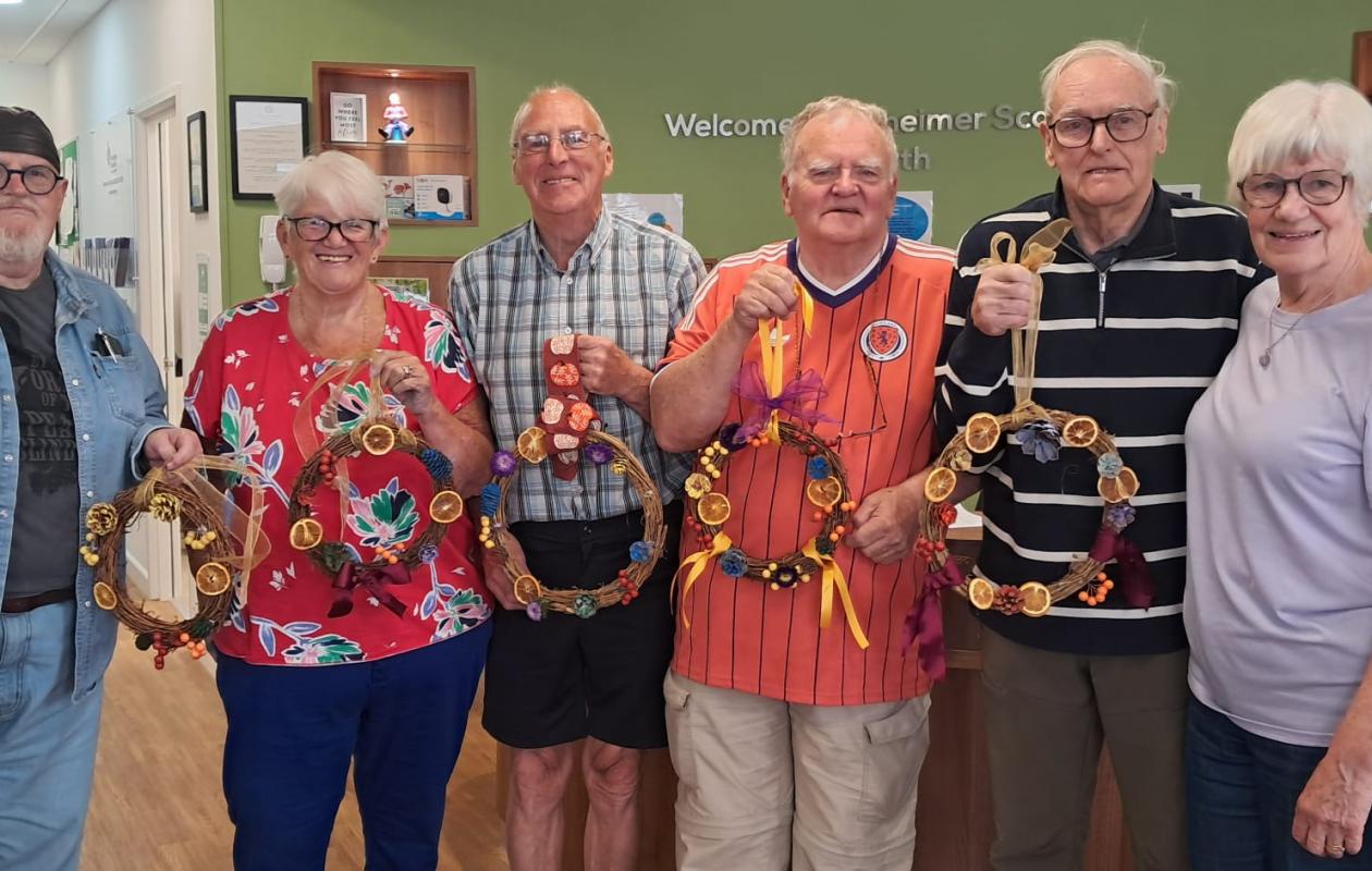 group of people holding up Autumn wreaths